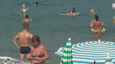 Türkiye, Antalya, 20 Ağustos 2015: Denizde yüzme ve güneşlenme sahilde insanlar