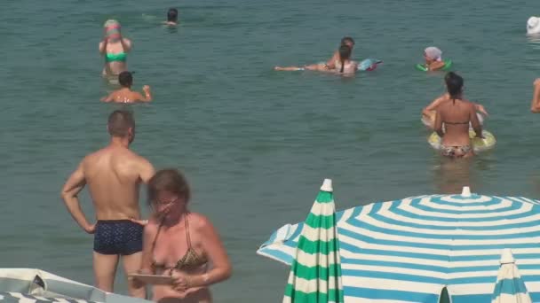 Türkei, Antalya, 20. August 2015: Menschen schwimmen im Meer und sonnen sich am Strand — Stockvideo