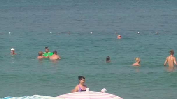 トルコ、アンタルヤ、2015 年 8 月 20 日: 人々 が海で泳ぐ、ビーチでの日光浴 — ストック動画