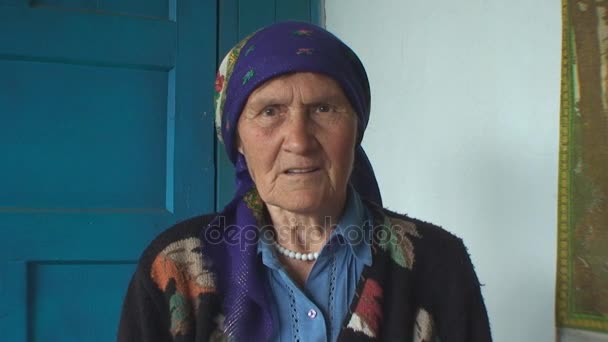 Die ältere Frau mit dem bunten Kopftuch — Stockvideo