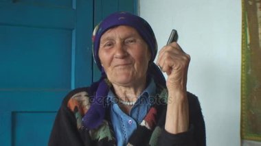 telefonda konuşurken bir renkli başörtüsü yaşlı kadın