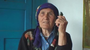 telefonda konuşurken bir renkli başörtüsü yaşlı kadın