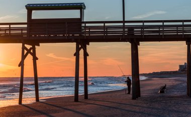 Silhouette iskele ve fotoğraf ile okyanus sahilinde renkli günbatımı