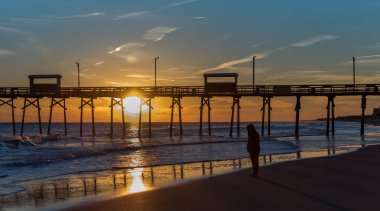 Silhouette iskele ve fotoğraf ile okyanus sahilinde renkli günbatımı