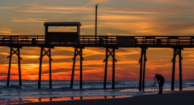 Silhouette iskele ve fotoğraf ile okyanus sahilinde renkli günbatımı