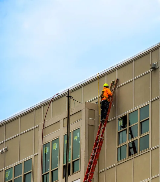 Trabajador de la construcción en escalera en el exterior del edificio — Foto de Stock