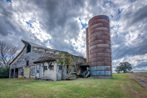 Antiguo granero abandonado con silo bajo nubes de tormenta — Foto de Stock