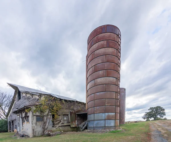 Opuszczona stodoła z silosem pod burzliwymi chmurami — Zdjęcie stockowe