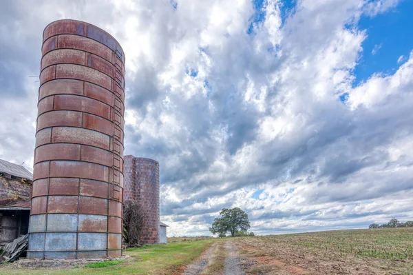 Granero abandonado con silo bajo nubes tormentosas — Foto de Stock