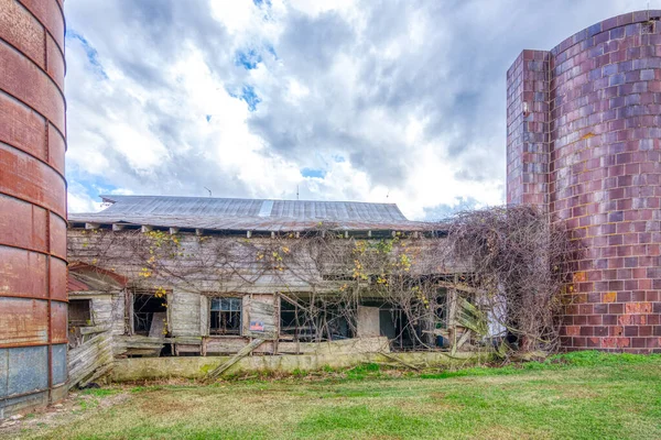 Celeiro abandonado com silo sob nuvens tempestuosas — Fotografia de Stock