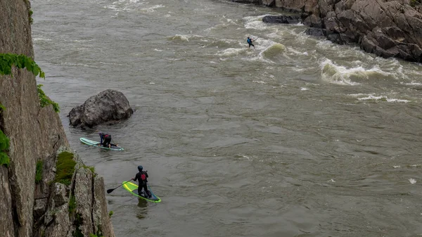Tři muži na kajaku pádlují po řece — Stock fotografie