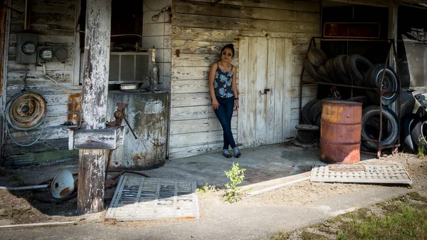 Frau steht und lehnt an Wand in verlassener Tankstelle — Stockfoto
