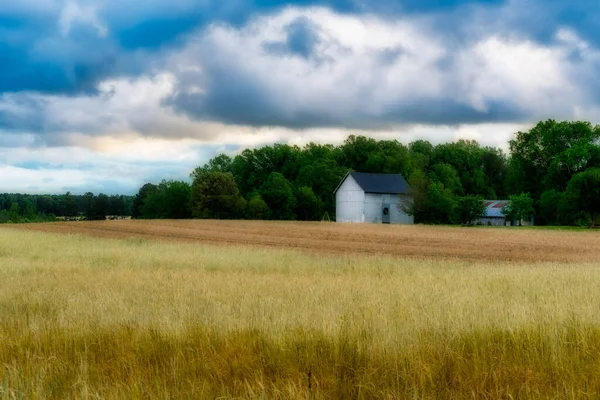 Grange blanche dans un champ avec ciel et nuages en arrière-plan — Photo