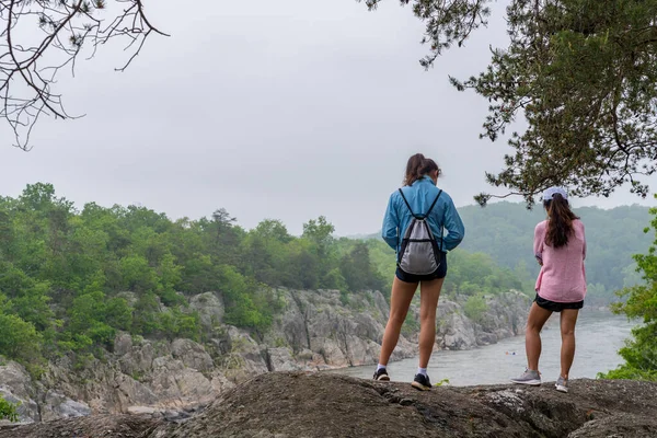 Mother and teen daughter standing on ridge on trail