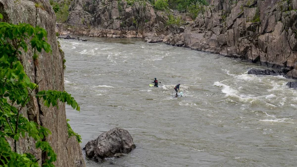 Two men on Kayaks paddlying on the river
