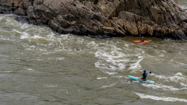 Two men on Kayaks paddlying on the river