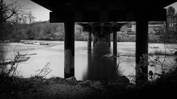 Bajo el puente de la autopista que cruza un río con agua suave — Foto de Stock