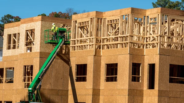 Obrero de la construcción elevado en plataforma hidráulica trabajando en bu — Foto de Stock