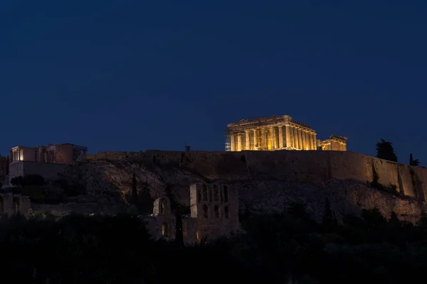 O parthenon e o acropolis iluminaram-se acima na noite — Fotografia de Stock