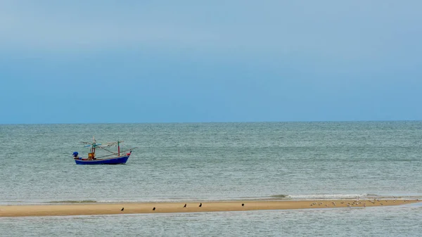 Рыбацкая лодка за песчаной полосой с птицами в Пак Нам Прам, Таиланд — стоковое фото