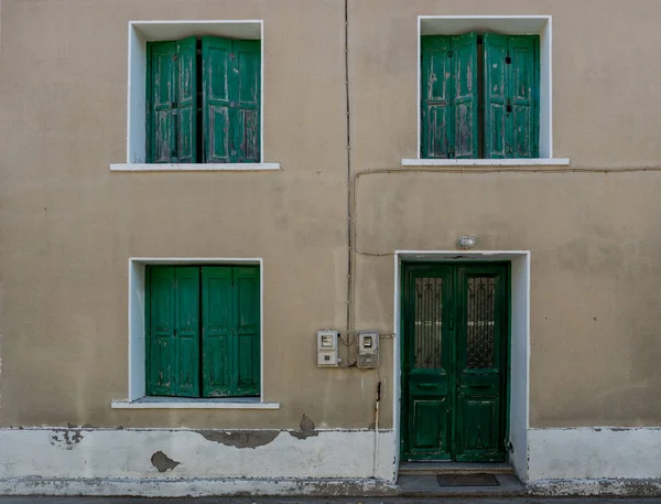 Edificio griego tradicional con persianas verdes y puerta — Foto de Stock