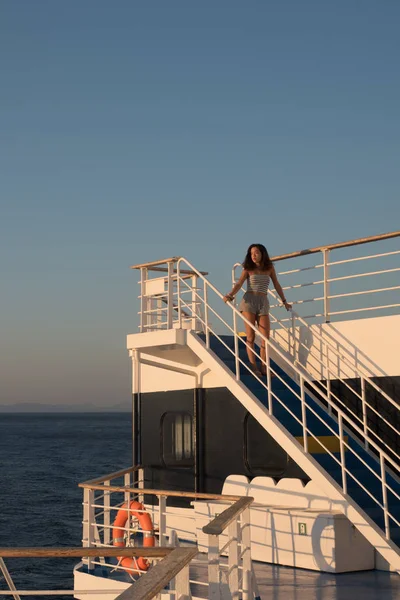 Teen ragazza in pantaloncini in piedi sulla cima della scala blu sul traghetto bo — Foto Stock