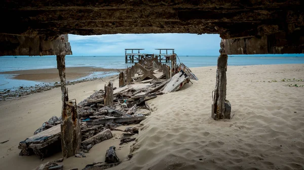 Dilapidated old fishing dock collapsing into the sea framed by d — 스톡 사진