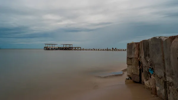 Detailní záběr na mořskou stěnu před zchátralým starým sloupcem doku — Stock fotografie