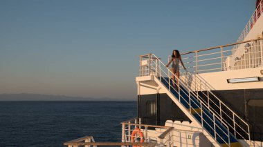 Mavi merdivenin tepesinde şortlu genç kız feribotla Yunanistan 'daki Lesvos' a gidiyor.