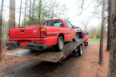 Kırmızı kamyonet Kuzey Carolina 'da kış günü çekilecek olan kırmızı kamyona yükleniyor.