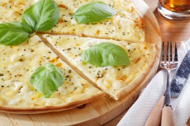Peynirli pizza ahşap tahta üzerinde dilimlenmiş