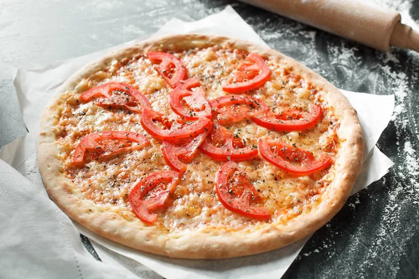 Heerlijke pizza met tomaat op donkere achtergrond — Stockfoto