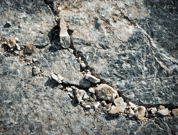 Spridda små stenar på en stor sten — Stockfoto