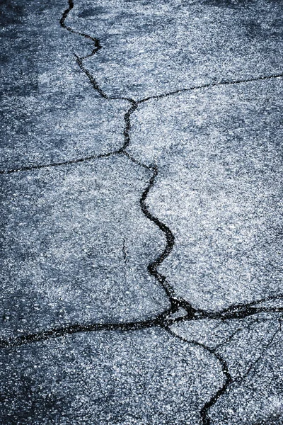 Fendas em um asfalto escuro — Fotografia de Stock