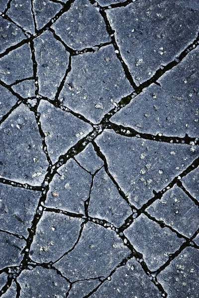 Grietas en una superficie de asfalto oscuro — Foto de Stock