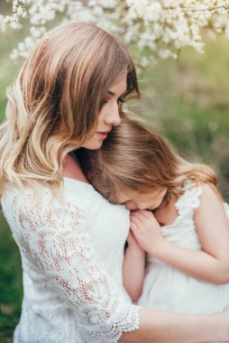 Güzel anne ve küçük kızı dışarıda. Doğa. Güzel anne ve çocuğu parkta birlikte oynuyorlar. Mutlu bir ailenin açık hava portresi. Anneler Günün kutlu olsun. Anne ve Bebek.