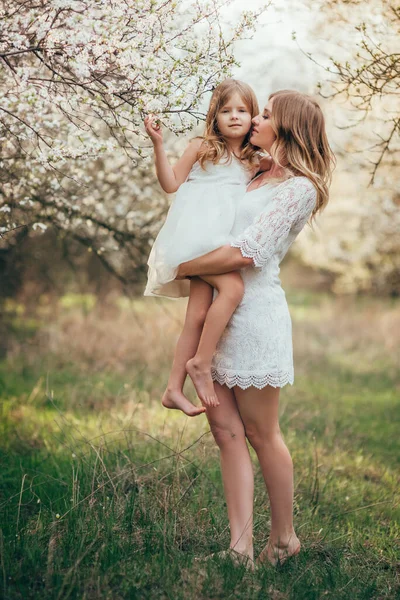 Vacker mor och hennes lilla dotter utomhus. Naturen. Skönhetsmor och hennes barn leker i parken tillsammans. Utomhusporträtt av lycklig familj. Glad mors dag glädje. Mamma och baby. — Stockfoto