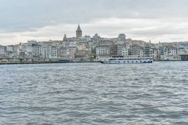 Gökyüzünde Galata Kulesi ve denizin üzerinde martılar olan İstanbul Panoraması. Galata Köprüsü ve yolcu gemileri ile günbatımında Golden Horn 'un geniş manzarası - reklam panonuz için seyahat arka planı.