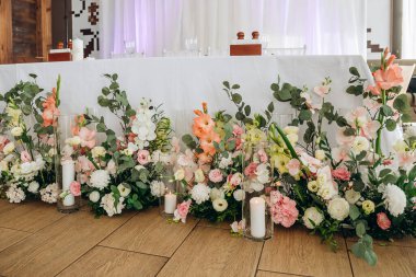 Çiçekli düğün süsü. Taze çiçeklerle süslenmiş düğün masası. Düğün çiçekçisi olarak. Güllü buket, Eustoma ve okaliptüs yapraklı..