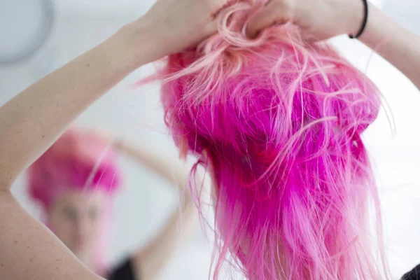 Aynaya bakarak roughed saçlı pembe saçlı kadın