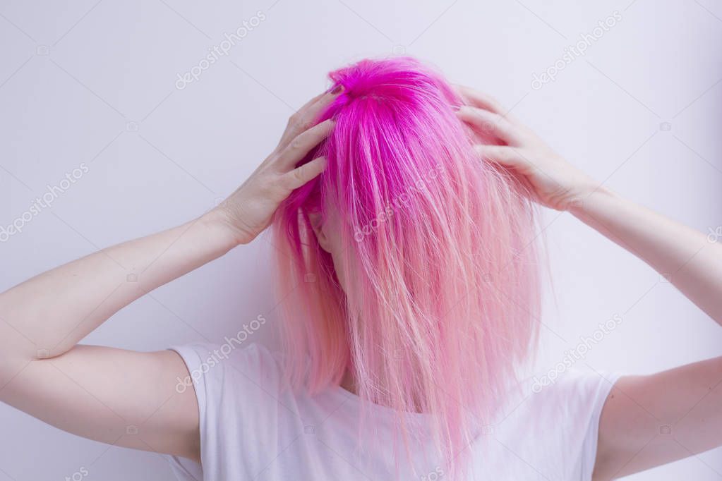 Crazy pink hair woman is touching her head by hands