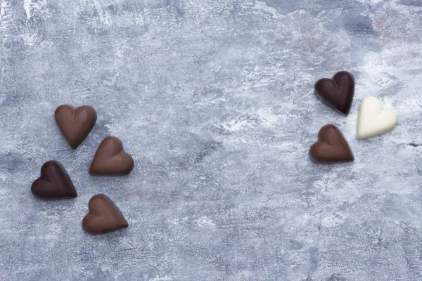 Gri dokulu arka planda kalp şeklinde çikolata