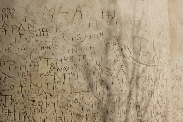 Baş harfleri eski duvarda çizik kalbin içindeki aşıkların 