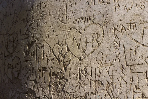 Baş harfleri eski duvarda çizik kalbin içindeki aşıkların 