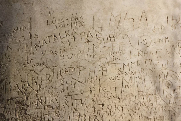 Baş harfleri eski duvarda çizik kalbin içindeki aşıkların 