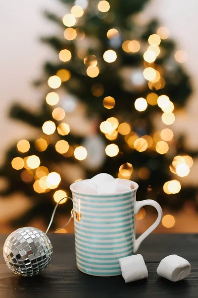 Karácsonyi kávé csésze marshmallows, a háttérben a New Year's fények és dekorációk. — Stock Fotó