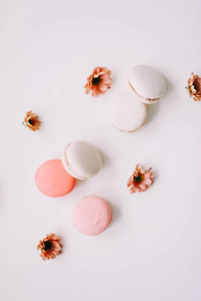 Tasty macarons cookies and flowers on white background. Colorful french desserts. March 8, Spring  background. Valentines, Women, Mothers day concept. Copy space, minimal style, flat lay, top view. — Stock Photo, Image
