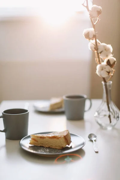 Кусок яблочного пирога на тарелке с чашкой кофе на белом столе. Завтрак с кофе и торт в кафе. пищевая фотография . — стоковое фото