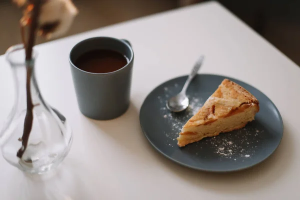 Sepotong pai apel di piring dengan secangkir kopi di atas meja putih. Sarapan dengan kopi dan kue di kafe. fotografi makanan . — Stok Foto