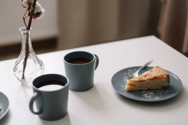 Кусок яблочного пирога на тарелке с чашкой кофе на белом столе. Завтрак с кофе и торт в кафе. пищевая фотография . — стоковое фото